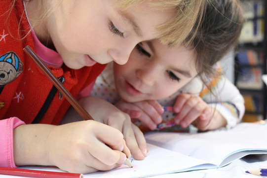 Zwei Schülerinnen der ersten Klasse arbeiten zusammen 