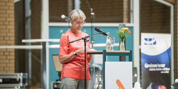 Frau Feller steht an einem Rednerpult