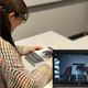 Eine Person nimmt an einem Eye-Tracking-Experiment teil und trägt mobile Tobii Pro Glasses 2. Die Daten des Experiments werden in Echtzeit auf einem Laptop angezeigt, während die Person ein Buch betrachtet.