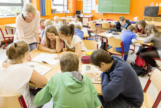 Schüler der 5. Klasse sitzen an einem Gruppentisch