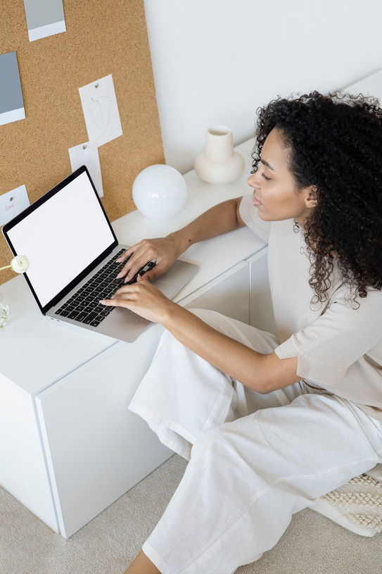 Frau sitzt am Schreibtisch mit Laptop