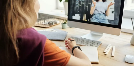 Person sitz vor Computer und schreibt