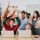 Mehrere Schüler*innen sitzen vor Laptops. Eine Lehrerin steht daneben.