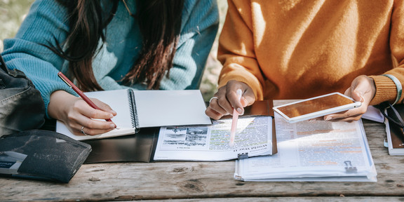 Zwei Studierende schauen in ein Buch