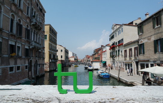 TU Logo steht in Venedig auf einer Brücke