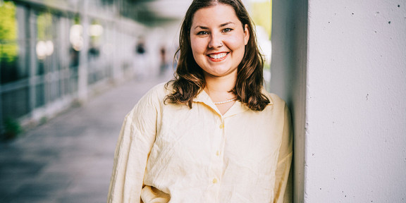 Frau lehnt an Betonwand