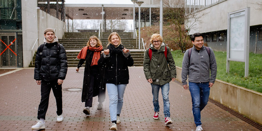 Studierende laufen über den Campus.