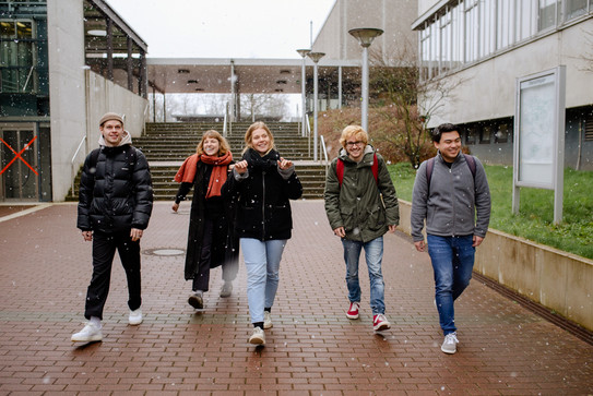Studierende laufen über den Campus.