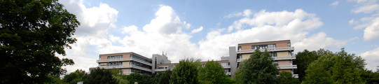 Emil-Figge-Straße 50 mit Wolken und grünen Bäumen im Hintergrund 